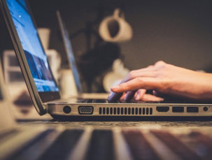 person using silver laptop computer on desk