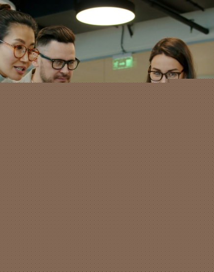 Diverse team collaborating around a laptop in office.